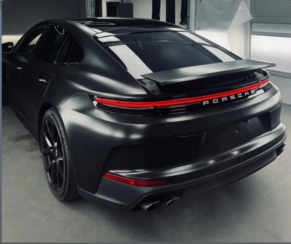 Arrière de la Porsche noire et bandeau lumineux dans l’atelier